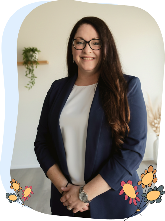 Woman with long brown hair and glasses wearing a navy blazer and white top, standing indoors with plants and floral graphics in the corners of the image.