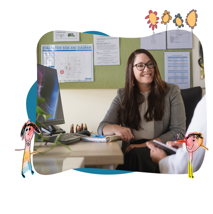 A woman in business attire smiles whilst sitting at a desk in an office, speaking with another person. Hand-drawn childlike figures and flowers decorate the image.