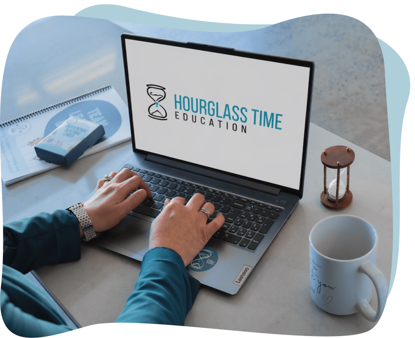 Person typing on a laptop displaying “Hourglass Time Education” logo, with an hourglass, notebook, pen, and mug on a desk.