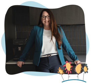 Woman with long brown hair and glasses stands in a modern kitchen, wearing a teal blazer and white top. Cartoon flowers decorate the bottom right corner of the image.